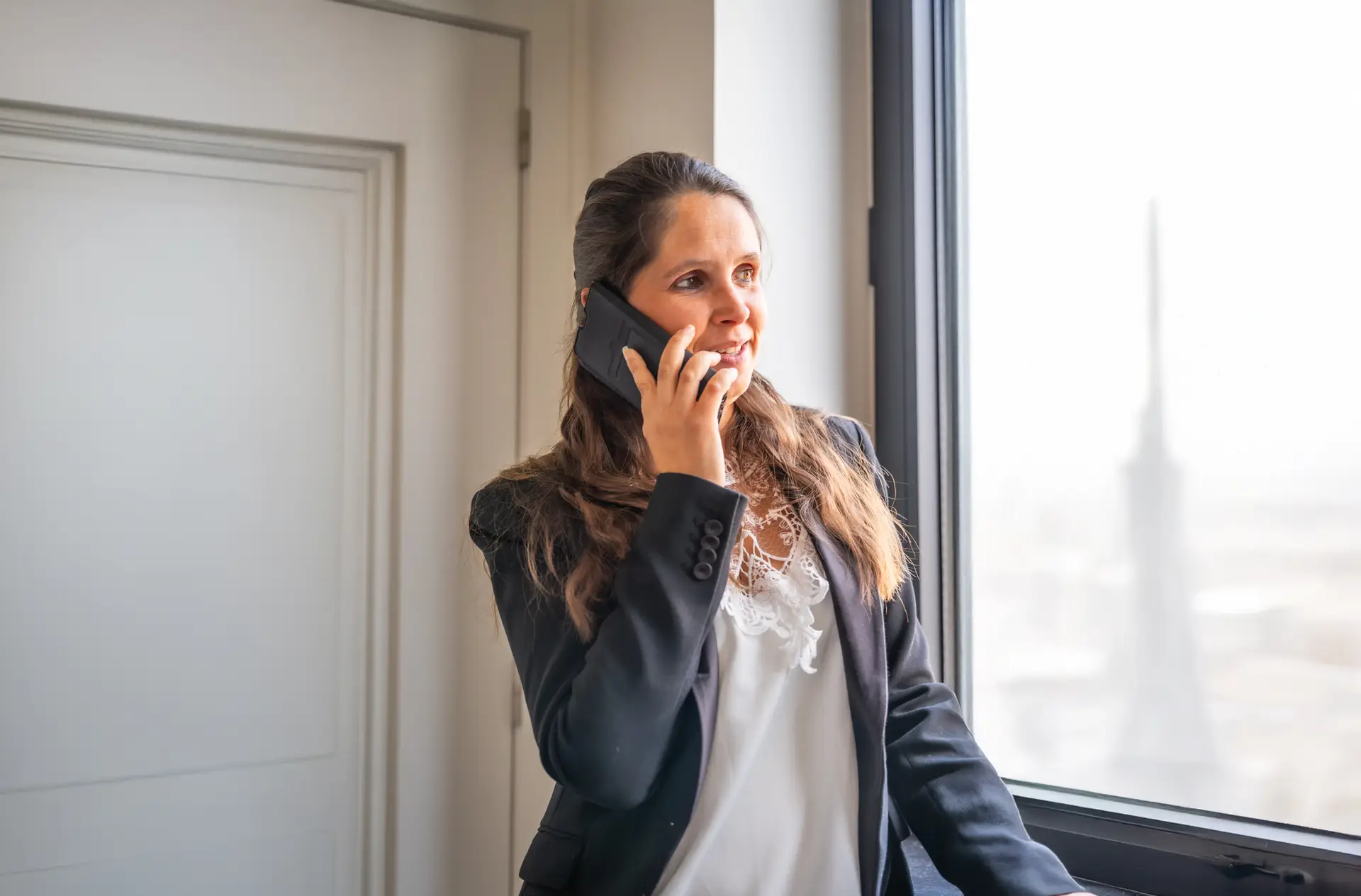 Zakelijke vrouw belt via mobiele telefonie van AT-COM – betrouwbare en flexibele telecomoplossingen voor KMO’s & bedrijven.